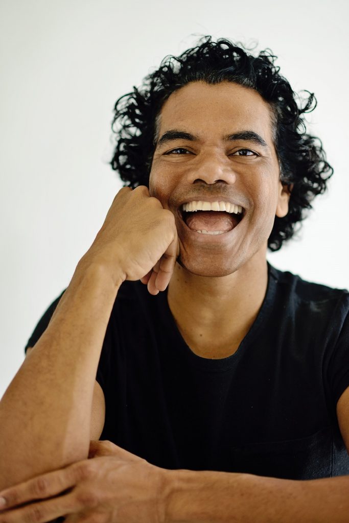 A portrait photograph of the dancer, comedian and actor Sean Choolburra smiling