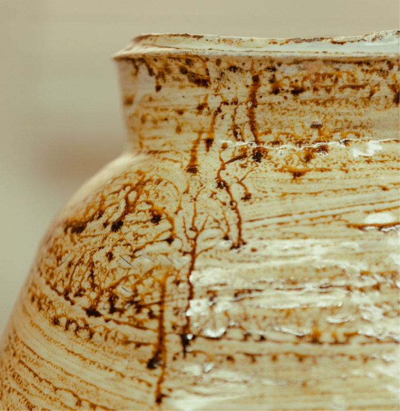 A detailed texture of glazing applied to a ceramic object, part of Remy Pajaczkowski-Russell's exhibition Moments of the Bay