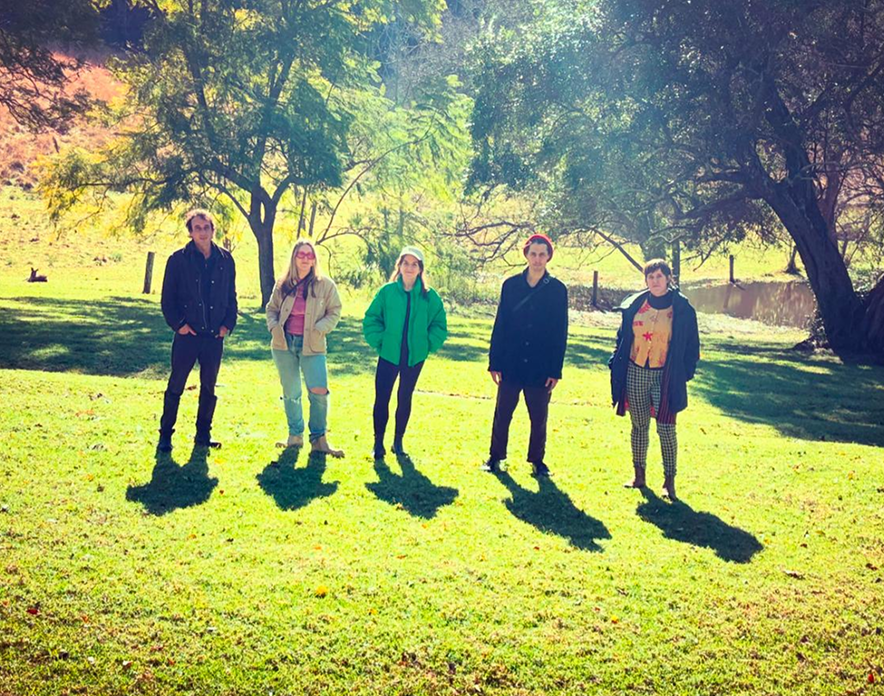 A photo of CIRCUL, a collective of sound artists standing on a green lawn.