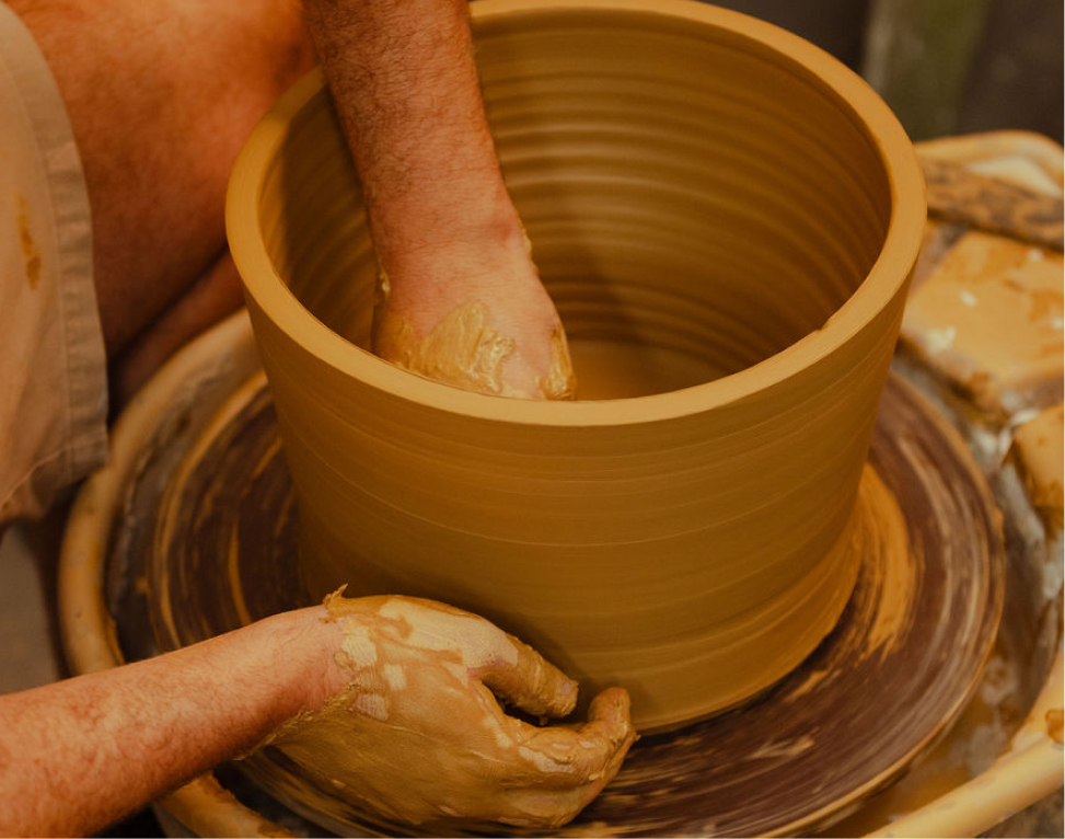 Remy Pajaczkowski-Russell Moments of the Bay - Hero Image showing two hands throwing a ceramic vessel on a pottery wheel